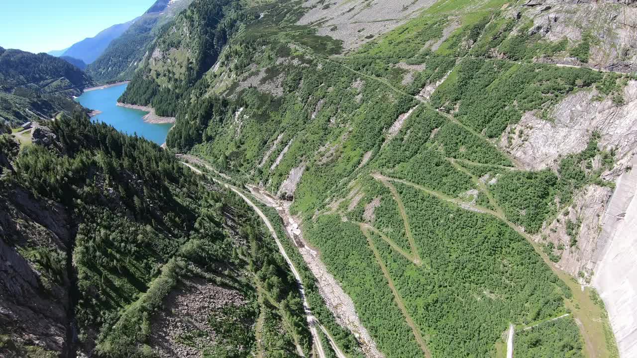 从奥地利卡林西亚Koelnbrein大坝上俯瞰山谷的全景。大坝被高山环绕着。陡峭的斜坡。山谷底部有一个长湖。自然能源视频素材