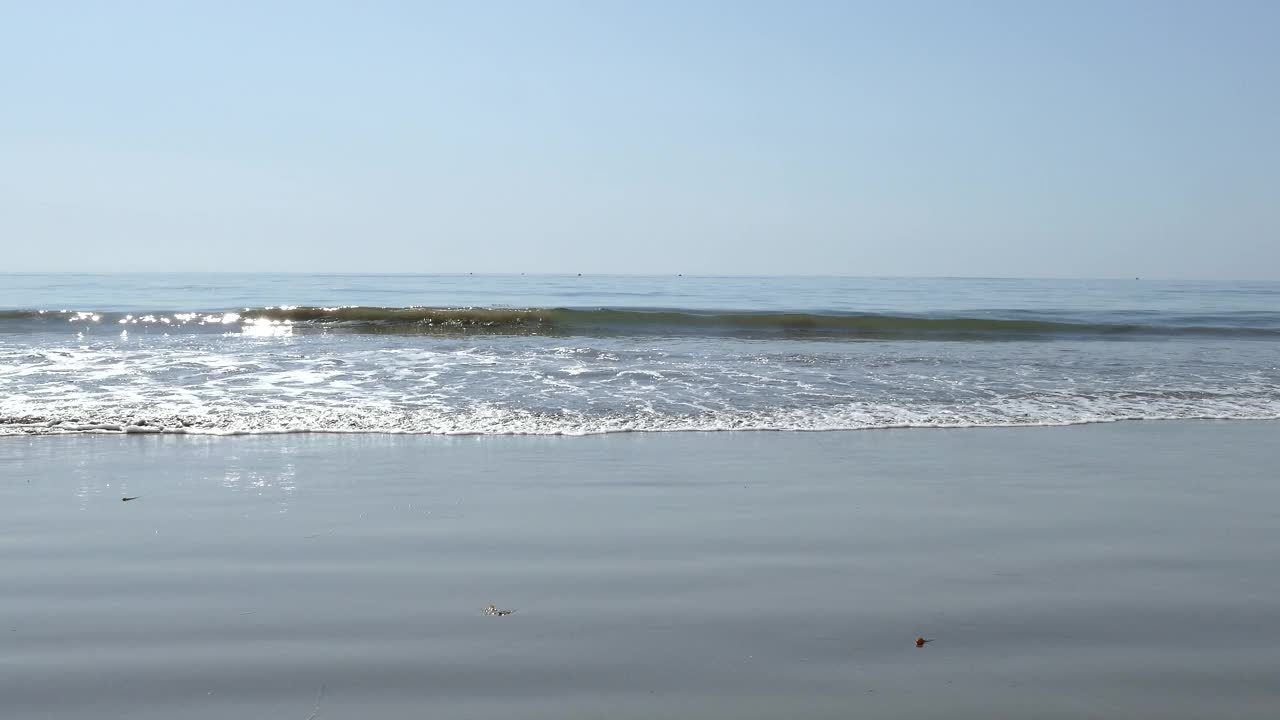 柔和的海浪拍打在潮湿的沙滩上，眺望着圣巴巴拉海峡视频素材