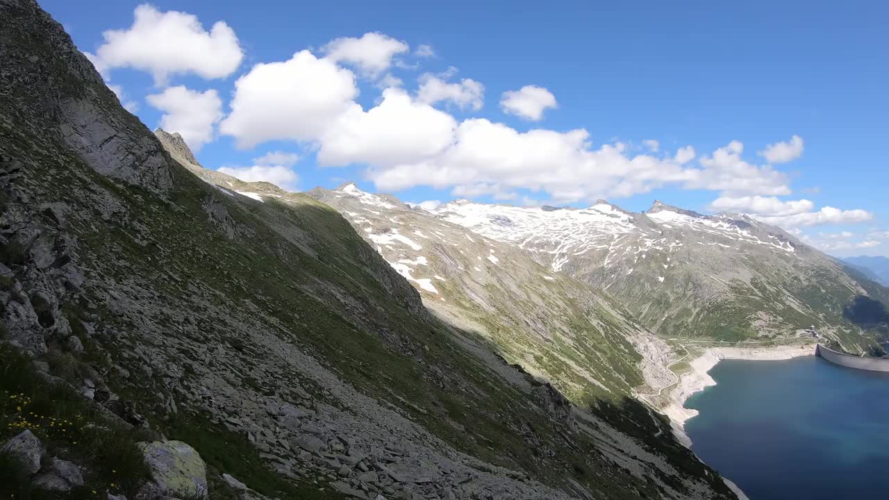 全景式的人工湖在科隆布雷因大坝在卡林西亚，奥地利。大坝被高山积雪覆盖的山峰包围着。陡峭的斜坡。这个湖是深蓝色的。自然能源视频素材