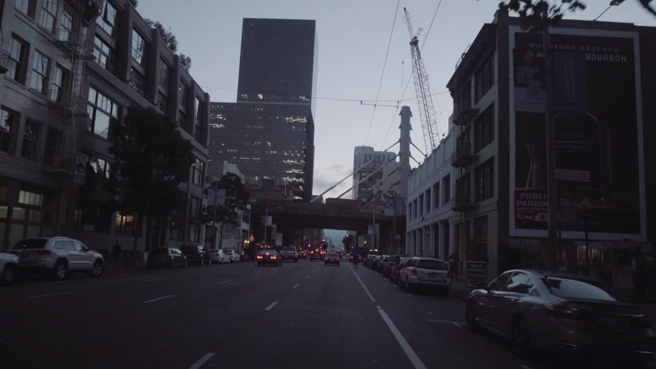 汽车在黎明时穿过城市街道视频素材