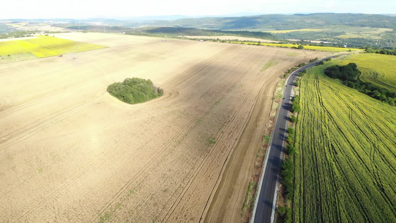 4K无人机拍摄了农田之间的一条笔直道路，三辆汽车在上面行驶视频素材