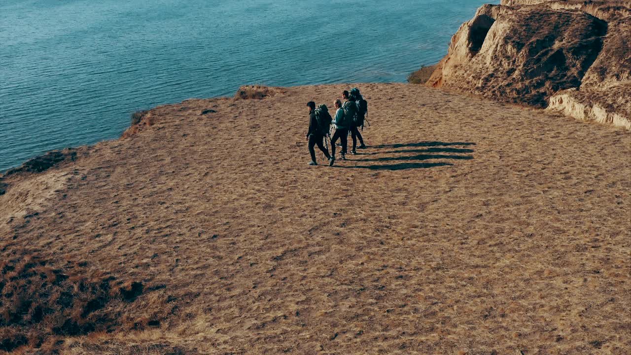 四个人站在海边的沙岩上视频素材