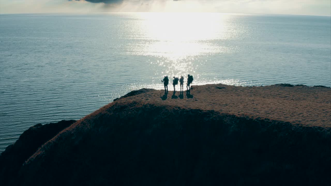 四个游客站在海边的山顶上视频素材