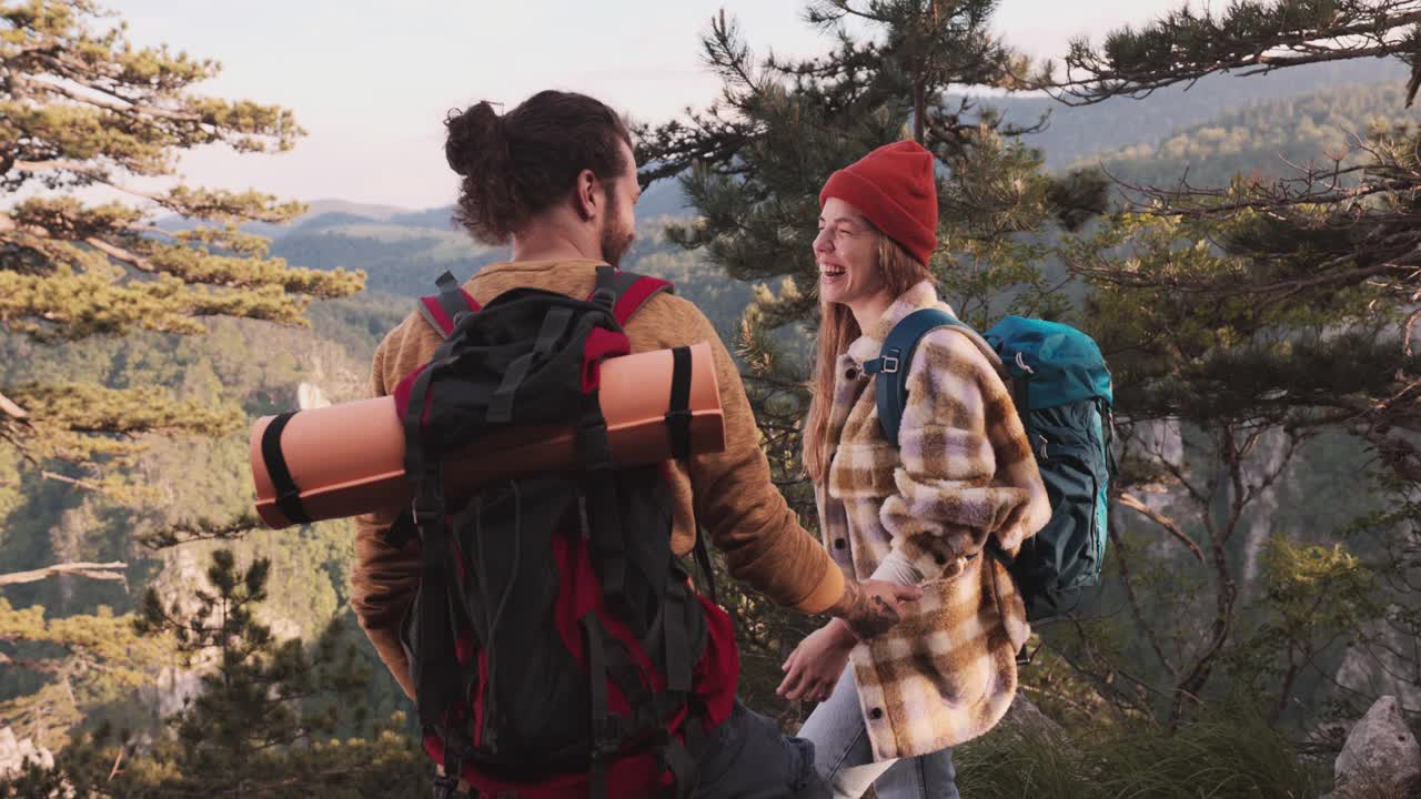 一对年轻的徒步旅行者一起欣赏美丽的景色。视频素材