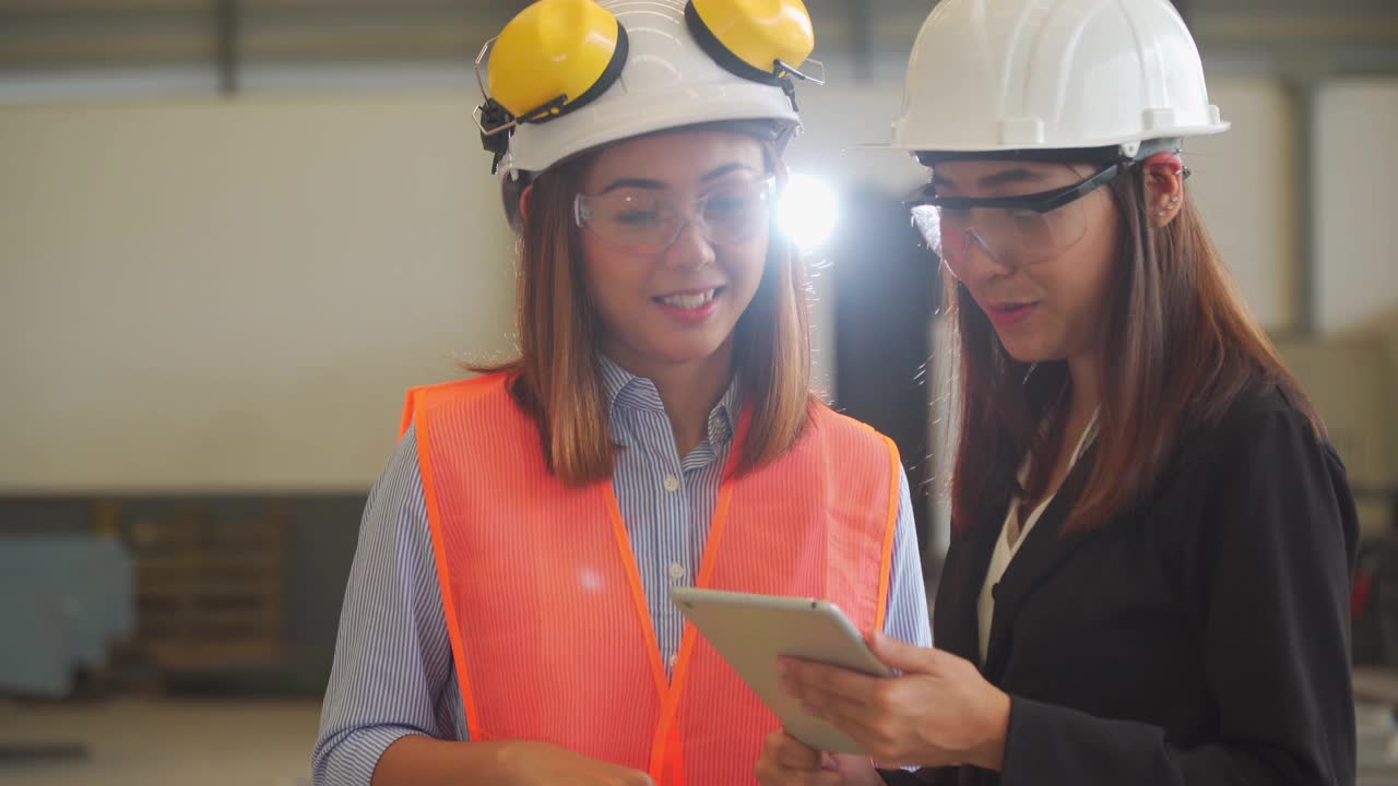 两名亚洲女建筑工程师在工地车间用平板检查工作。视频素材