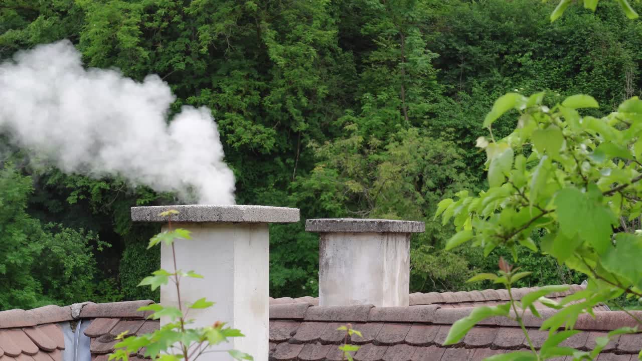 夏天，白烟从石砌烟囱升起。视频素材