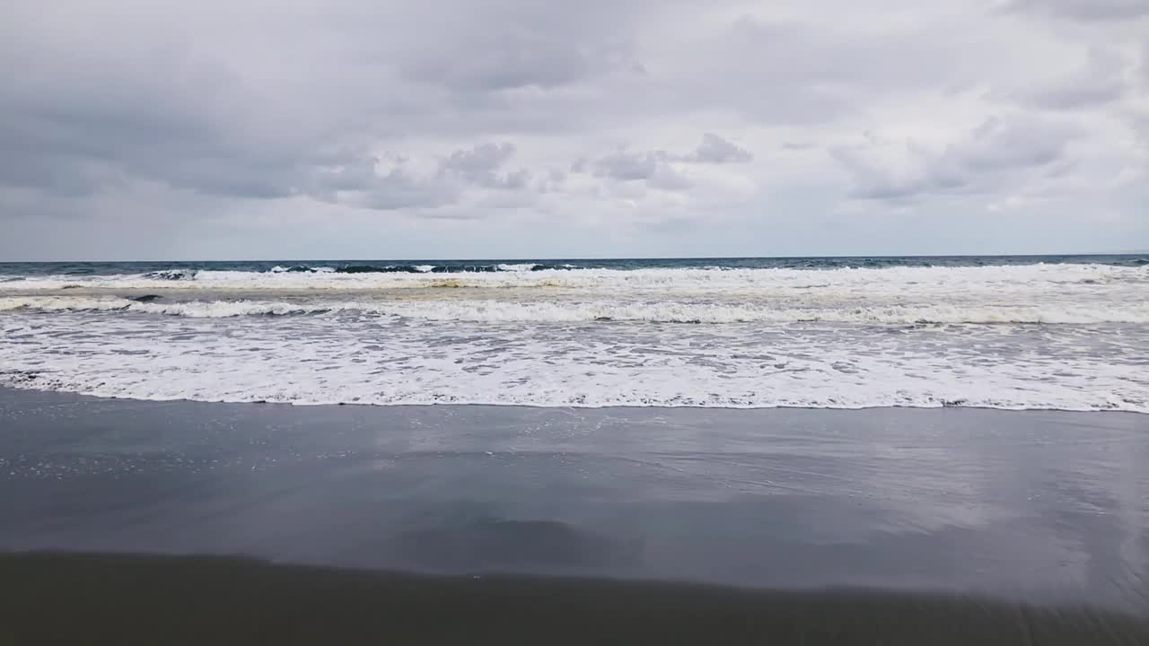 海洋/海岸上的黑砂火山海滩。视频素材