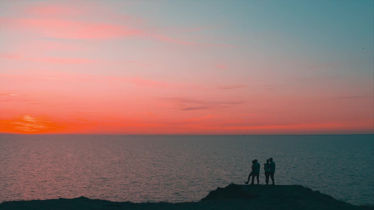 年轻人站在山顶，面对美丽的海景视频素材