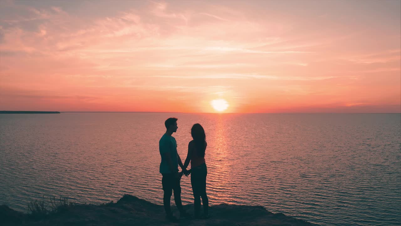 一男一女站在山顶，眺望着美丽的海景视频素材