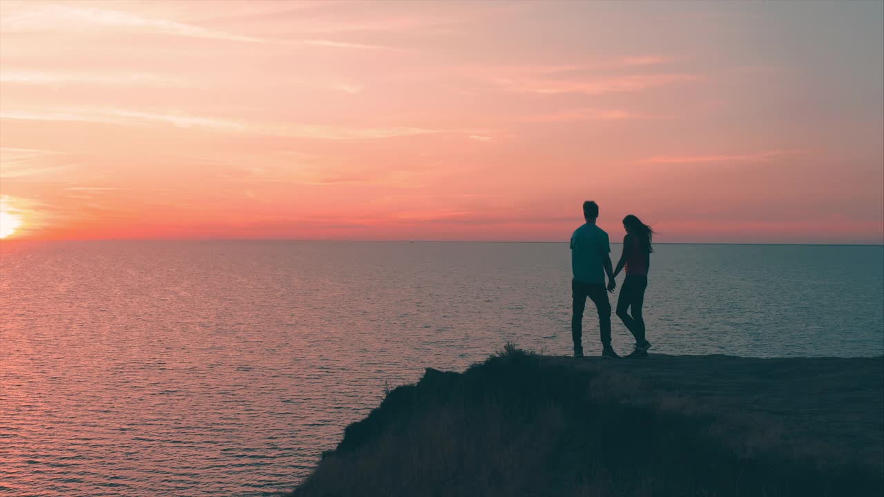 一男一女站在山顶，眺望着美丽的海景视频素材