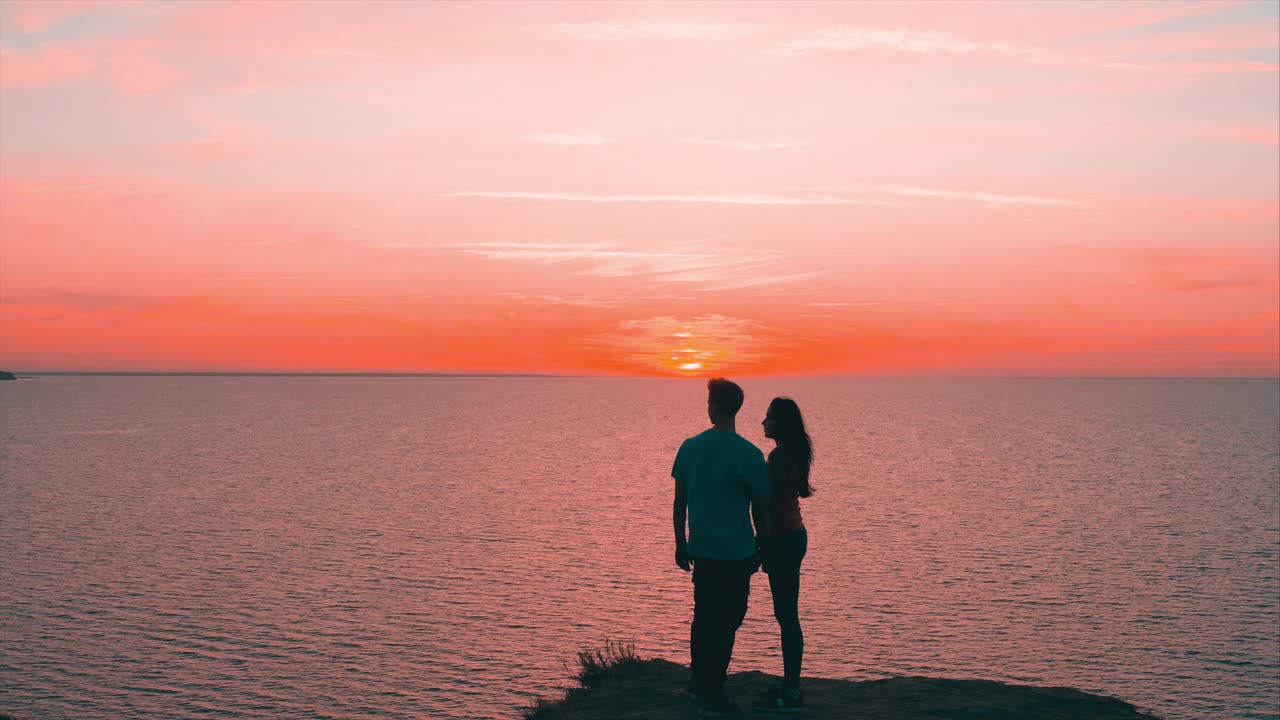 一男一女站在山顶，眺望着美丽的海景视频素材