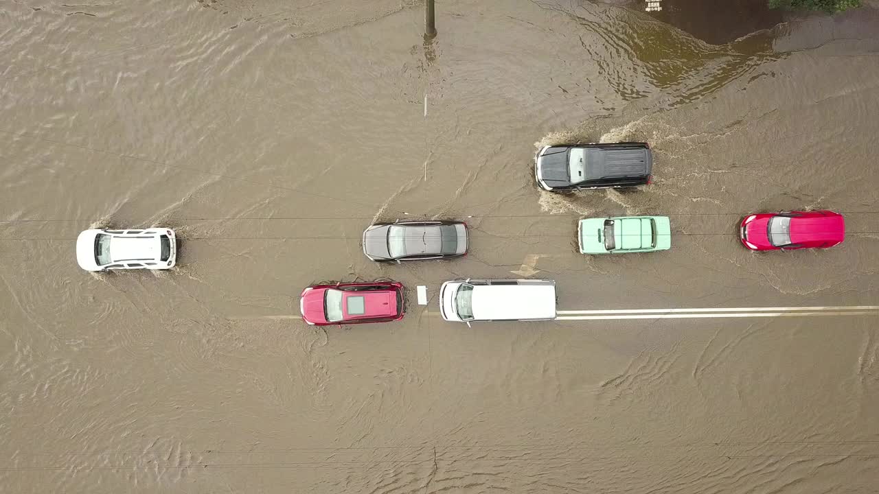 交通车辆在被雨水淹没的道路上行驶的鸟瞰图。视频素材