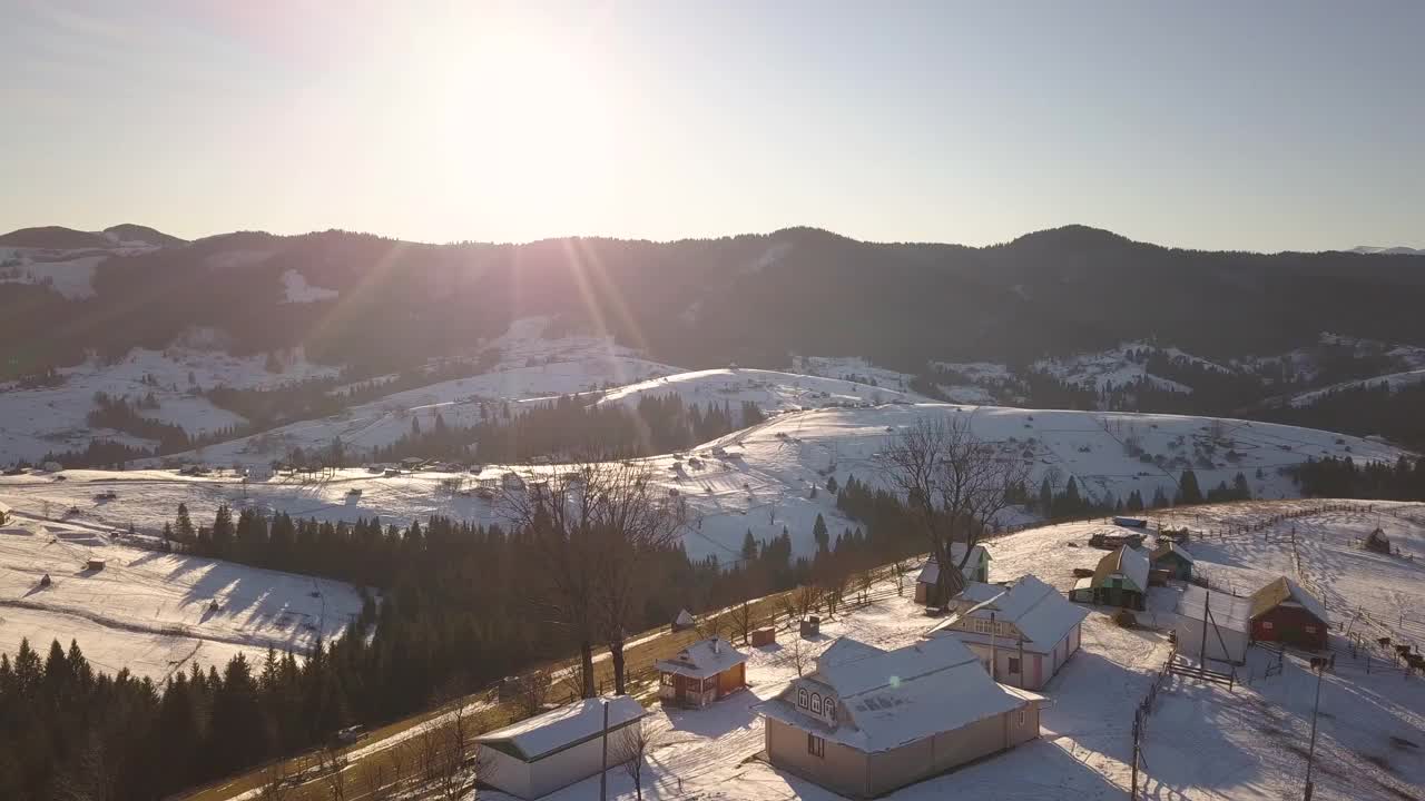 鸟瞰图上的小村庄，在冬天被雪覆盖的山丘上散落着房屋，裸露的喀尔巴阡山脉在乌克兰。视频素材