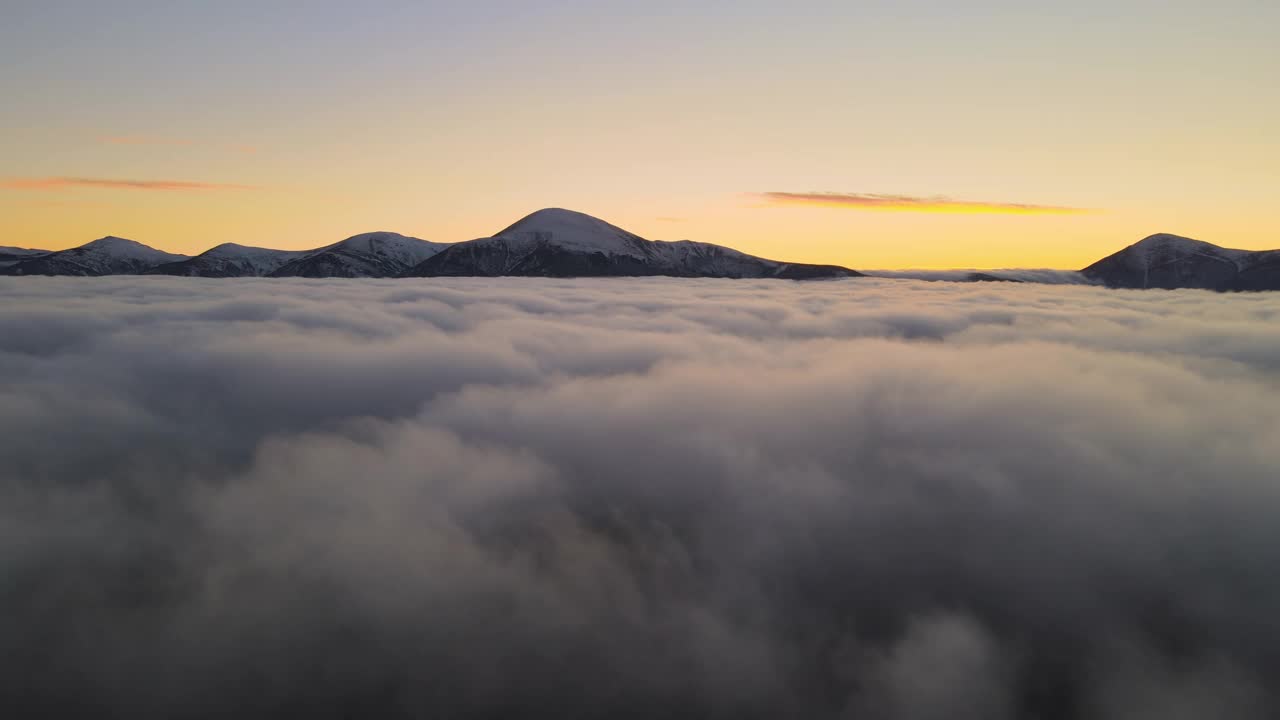 鸟瞰图生机勃勃的日出在白色的浓雾与遥远的喀尔巴阡山脉在地平线上黑暗的山峰。视频素材