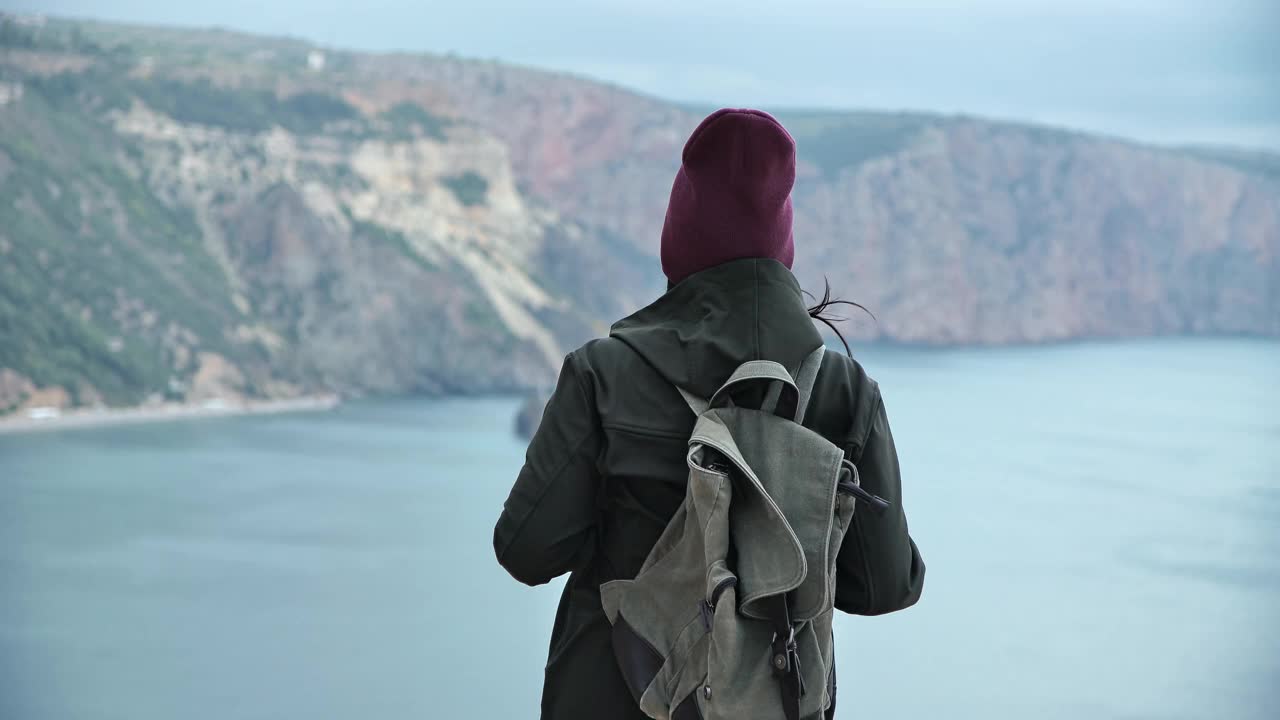 背景旅行背包女跳跃庆祝胜利在高山上越过海视频素材