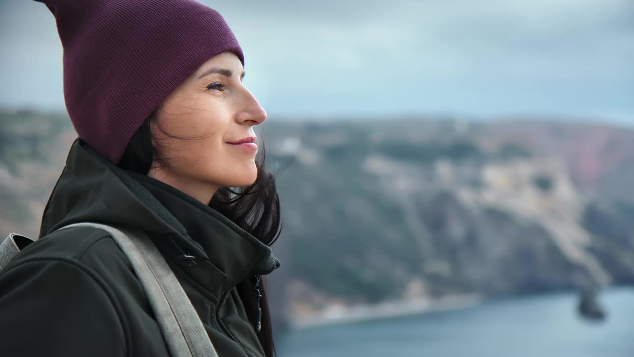 特写快乐的旅行女人欣赏惊人的自然风景与海从高山顶视频素材