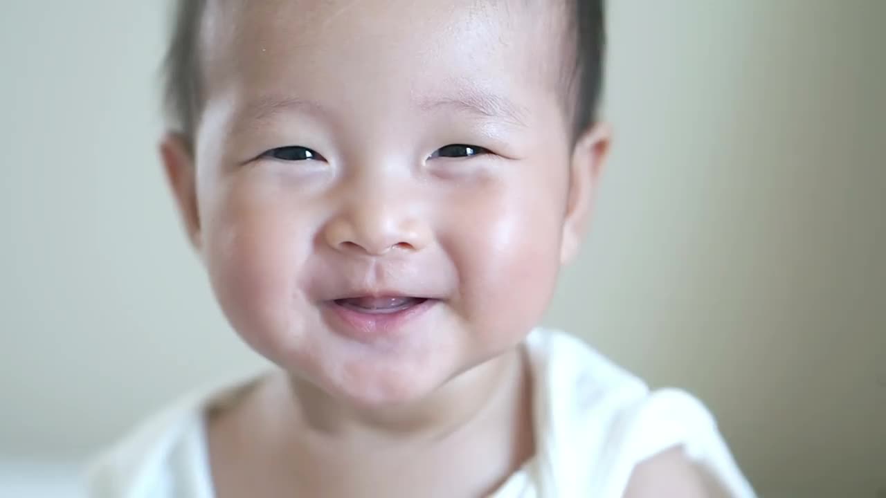 特写快乐微笑亚洲可爱的宝贝女孩，宝宝积极的情绪，快乐的时间概念视频下载