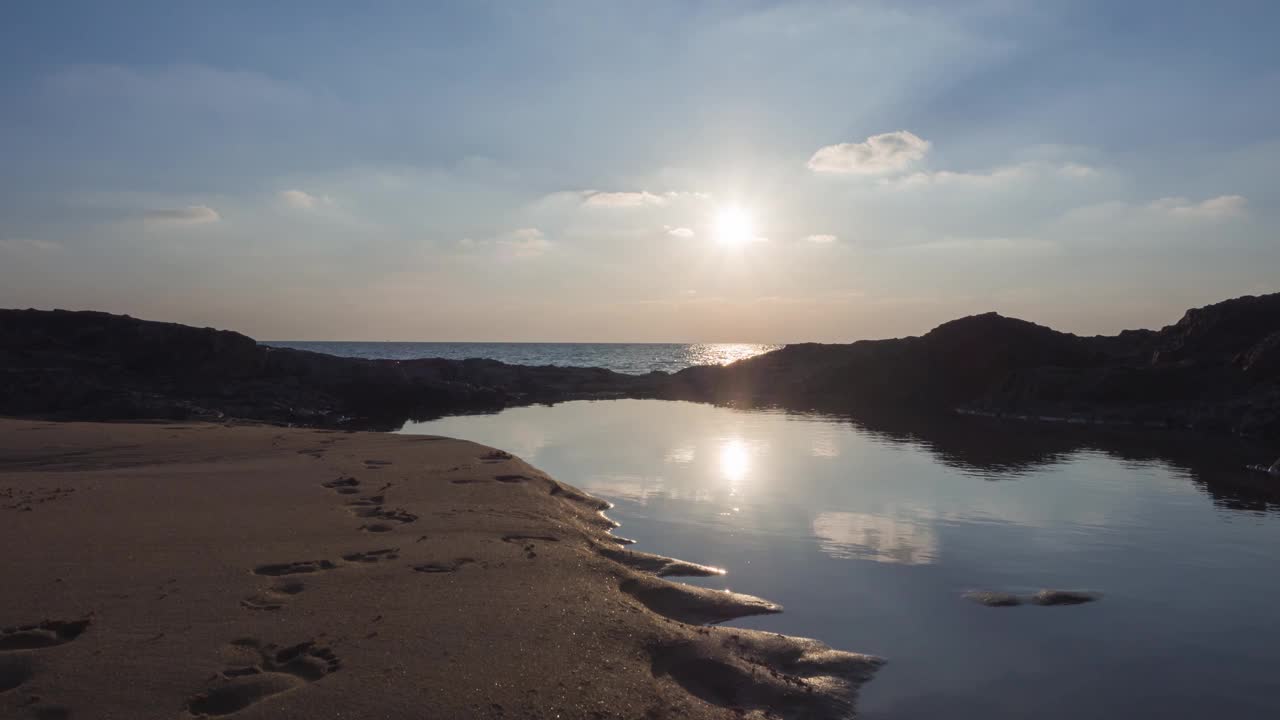 美丽的彩色日落与灰色的云。阳光照在海水上，海浪在沙滩上撕裂，自然的颜色的天空和日落在地平线。泰国自然景观的天堂视频素材