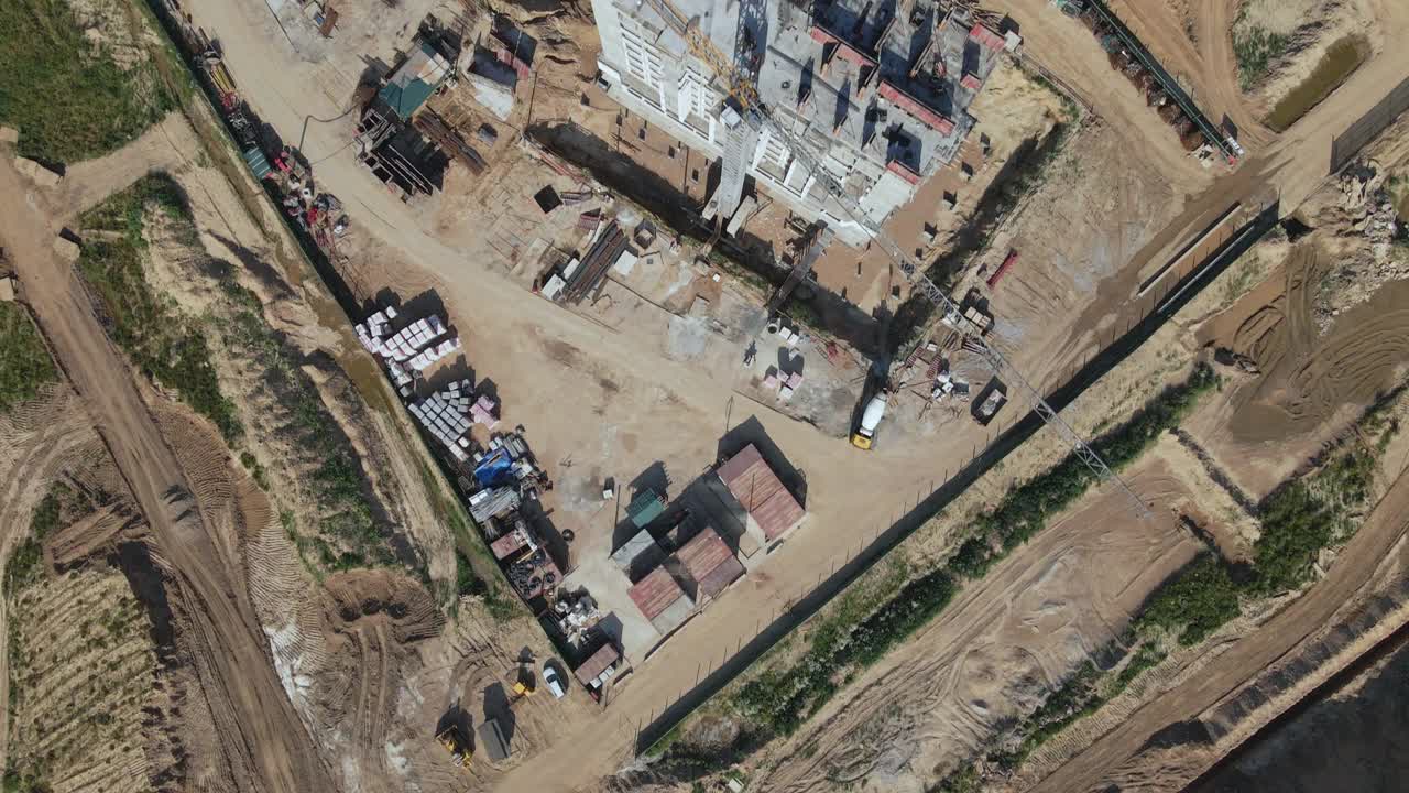 建设一个现代化的城市街区。建筑的混凝土框架在建筑工地是可见的。施工起重机正在工作。航空摄影。视频素材