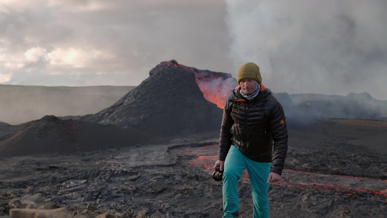 摄影师走在喷发的Fagradalsfjall火山熔岩流前视频素材