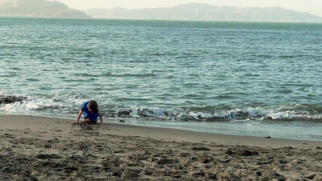 孩子们在金门大桥附近的旧金山湾海滩上玩耍视频素材