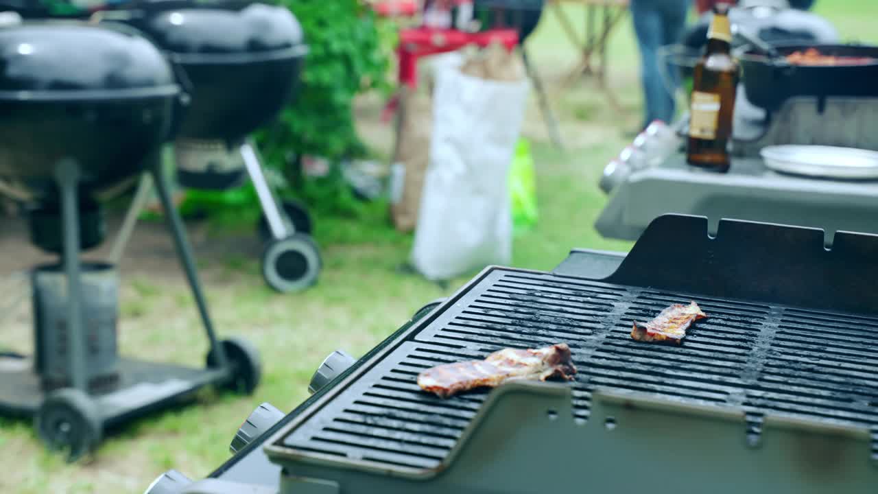 烧烤网准备为周末野餐派对，肉片在炭火烧烤网格上烤。美味的烤肉袅袅升起，食物烧烤派对视频素材