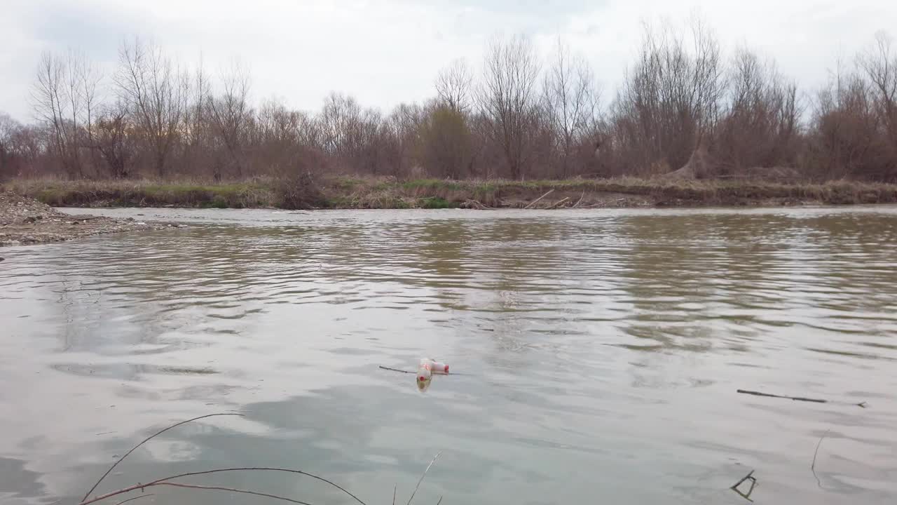 滥用环境。浑水。垃圾漂浮在海岸附近的河流或湖泊里视频素材