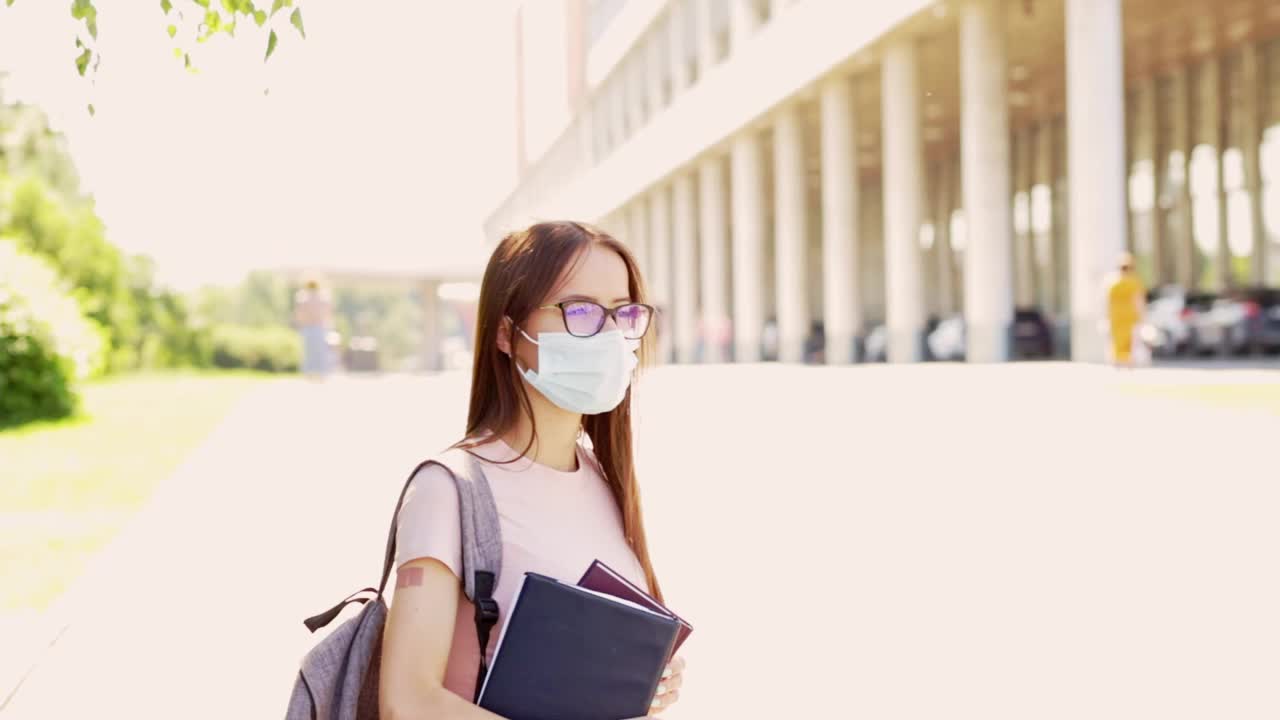 学生接种疫苗，少女接种疫苗后随手贴膏，新冠肺炎疫情结束后返回学校或学院或大学视频素材