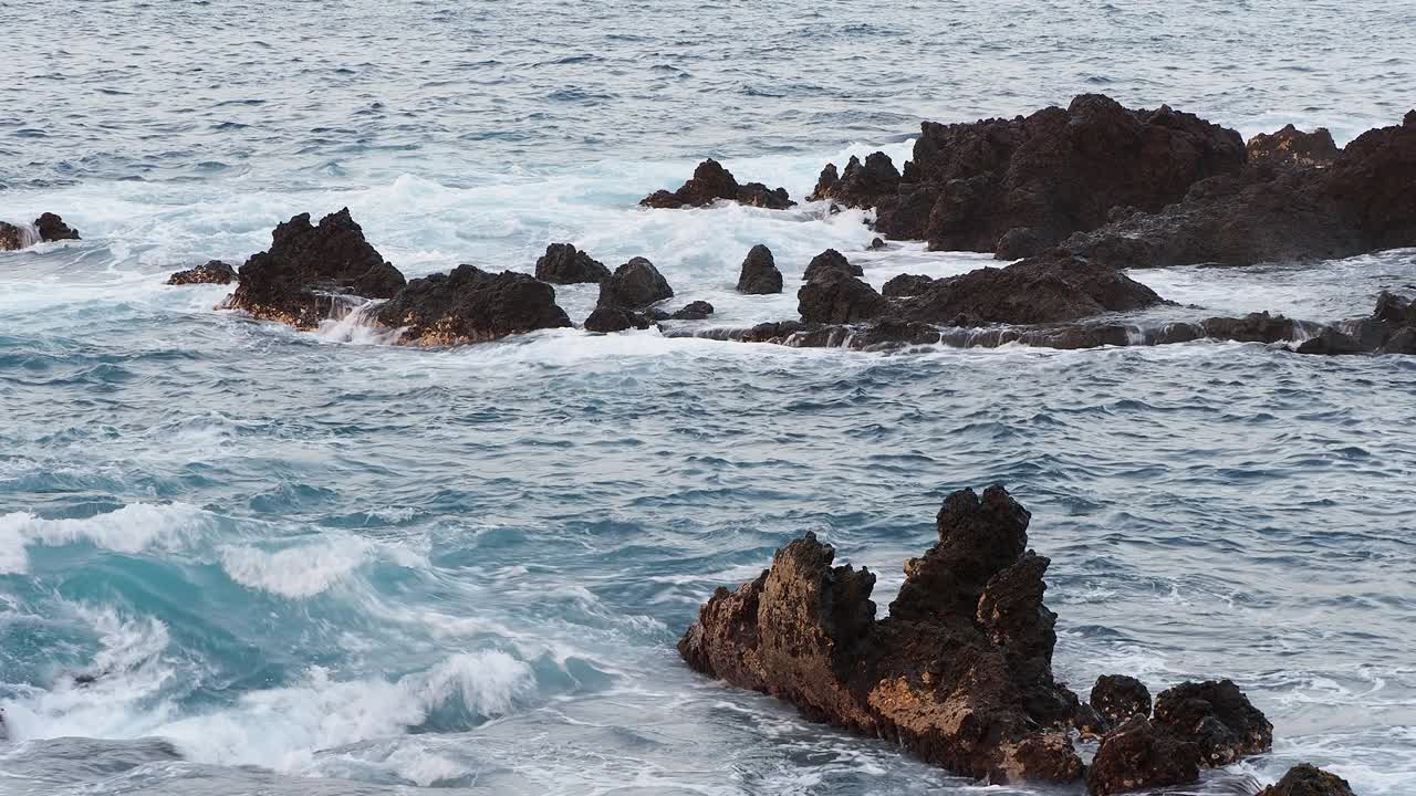 海浪撞击火山岩石的海岸景观。视频素材