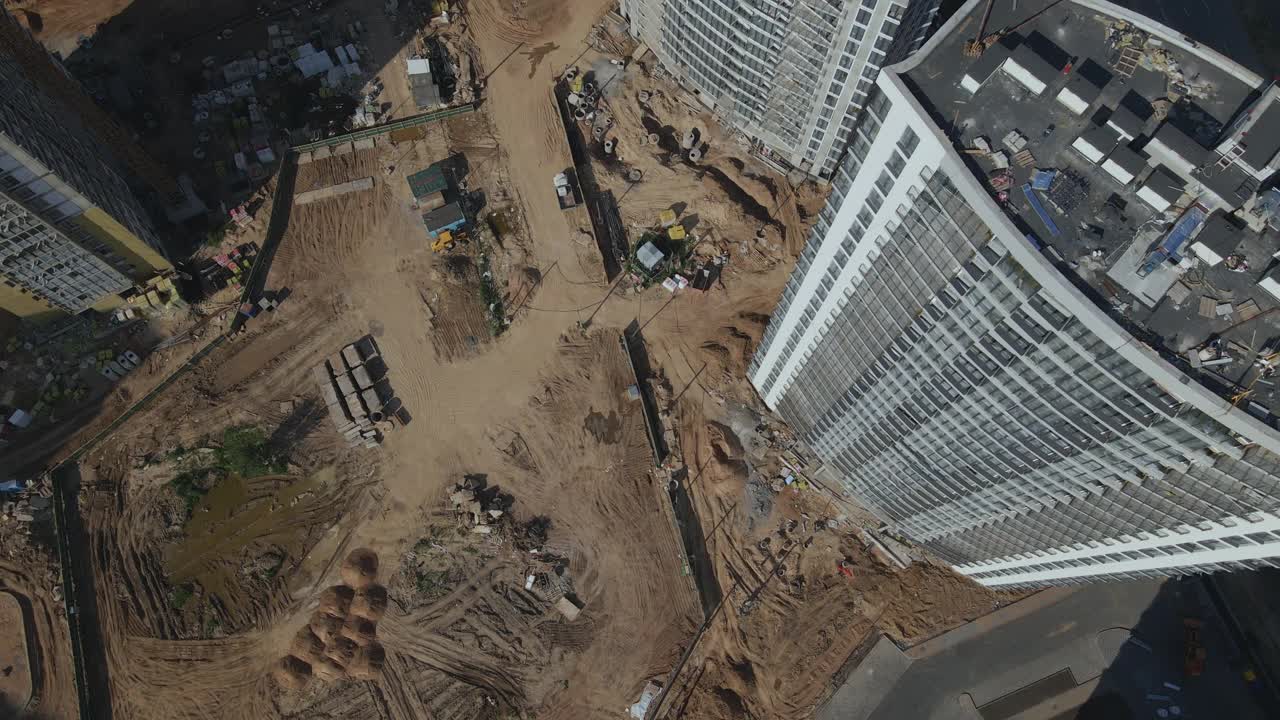 建筑工地。建筑物的混凝土框架正在建造中。施工起重机正在工作。城市建筑随处可见。航空摄影。视频素材