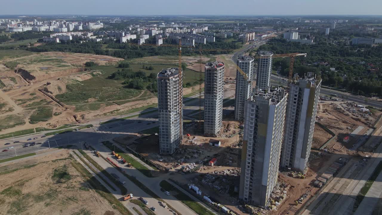 建筑工地。建筑物的混凝土框架正在建造中。施工起重机正在工作。城市建筑随处可见。航空摄影。视频素材