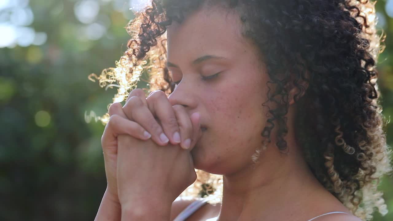 年轻的西班牙裔女子在外面祈祷。拉丁崇拜，祈求上帝的帮助视频素材