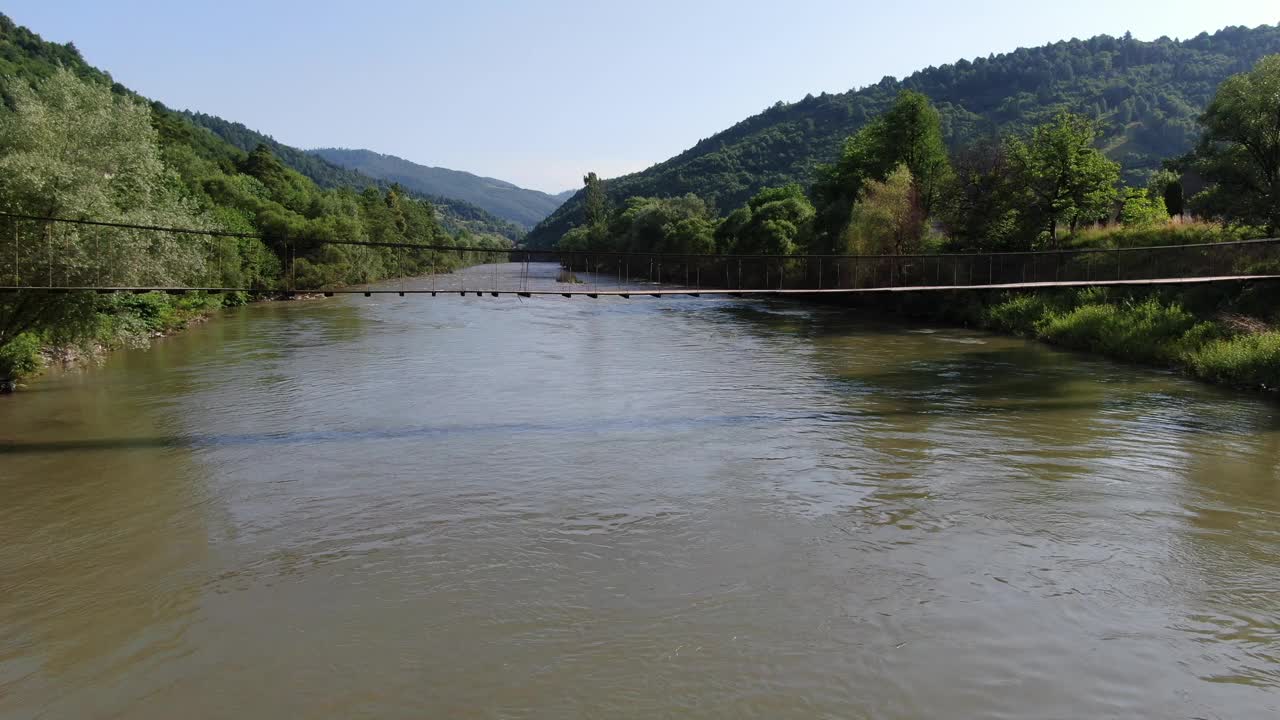 一座悬在山间河流上的木桥视频素材