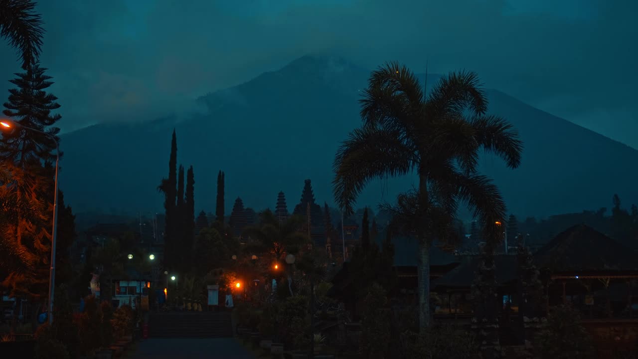 街道在夜晚的黑暗与云彩和蓝色的天空在背景覆盖火山视频素材