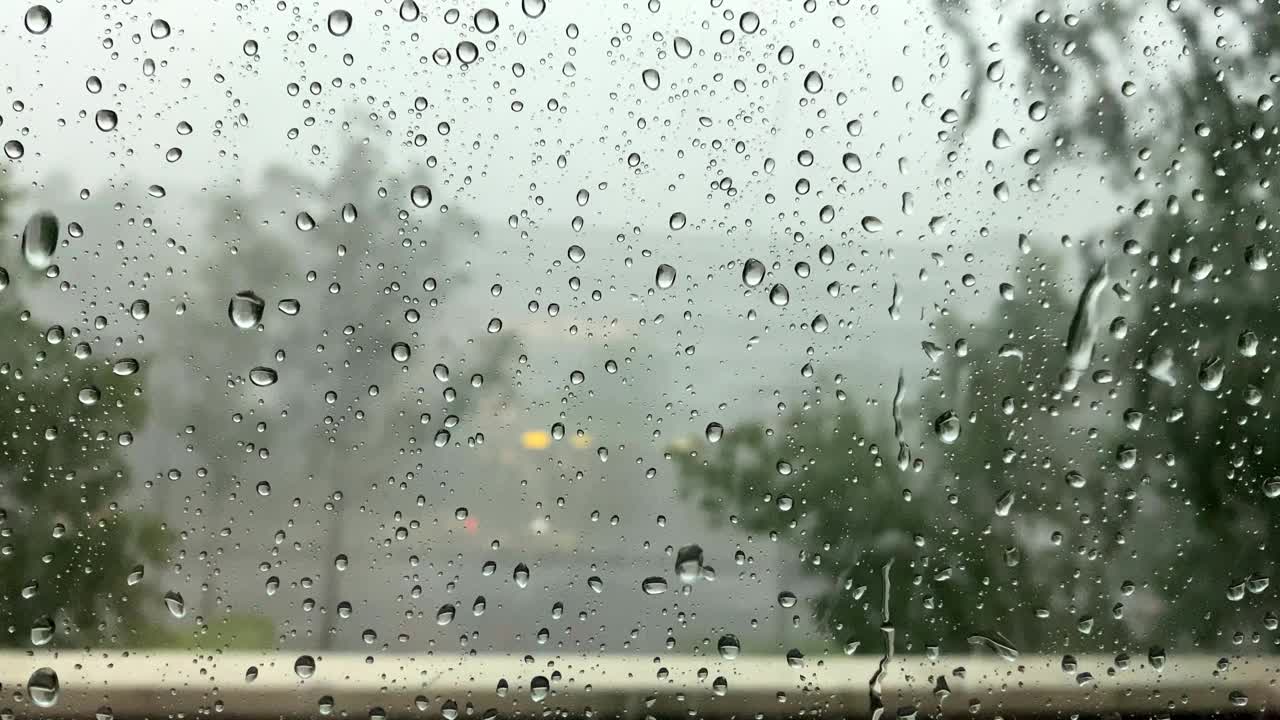 在特写镜头中，大雨中的雨滴顺着窗户流下。飓风风视频素材