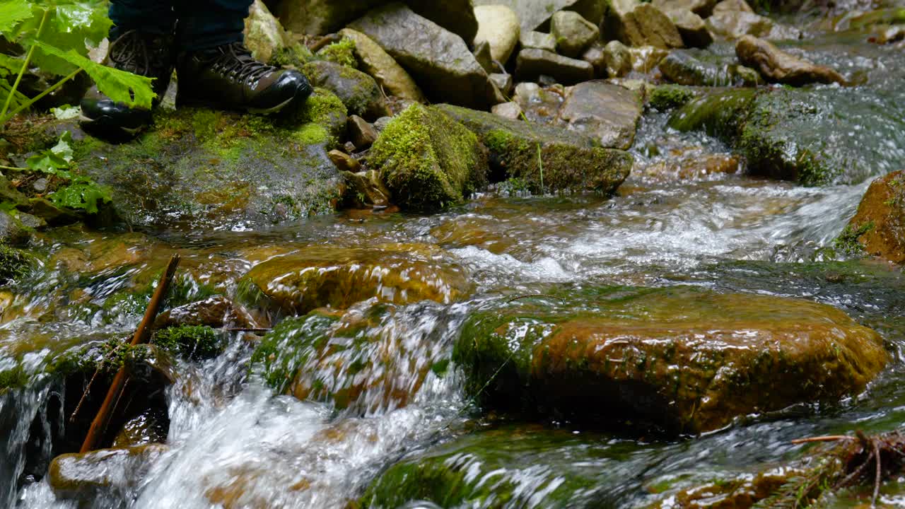 复古皮革登山靴徒步旅行者滚动山溪的特写视频素材