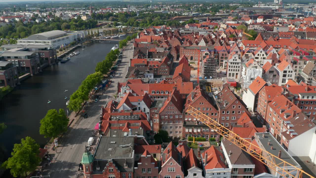 空中滑动镜头的历史砖镇住宅，宽阔的滨河街道和特拉弗河。Luebeck,石勒苏益格-荷尔斯泰因州,德国视频素材