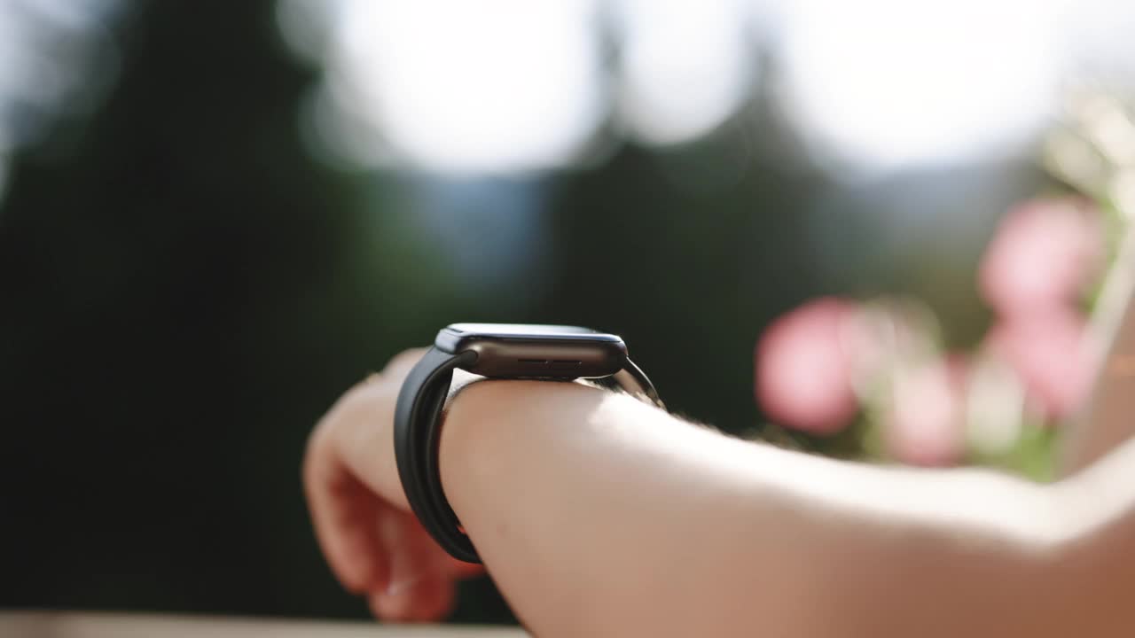 Smartwatch。户外女人手上的智能手表。女孩的手在触摸智能手表。智能手表滚动显示。娱乐与科技概念视频素材