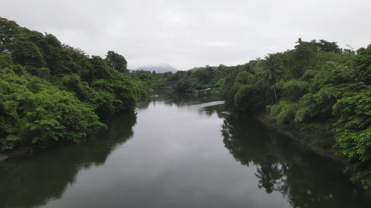 鸟瞰绿色自然与宁静的河流，雨后飞越热带绿色森林视频素材