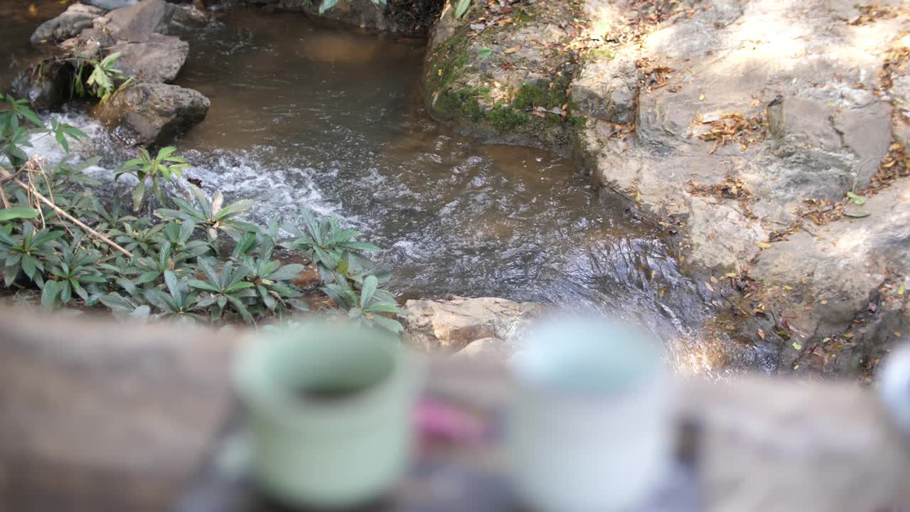 在小瀑布附近的咖啡馆喝热饮料视频素材