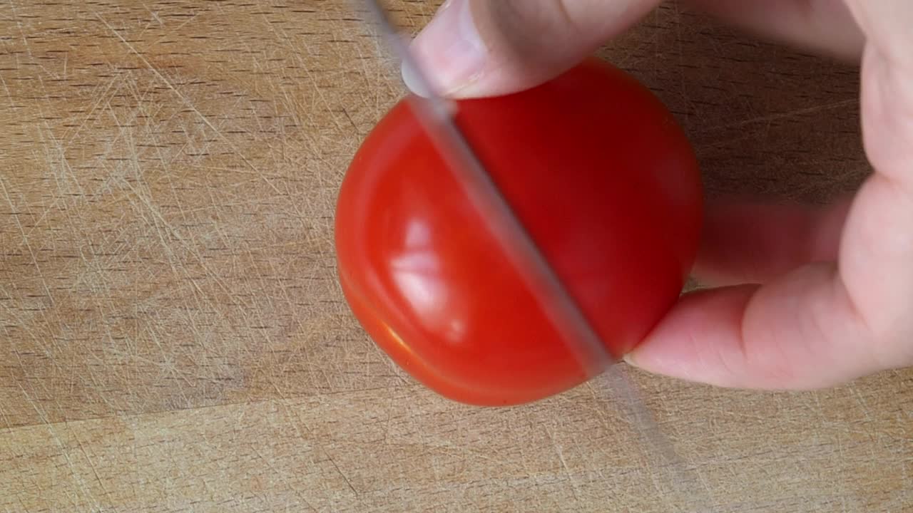 熟透的红番茄在木板上切成片。用蔬菜烹饪健康饮食菜肴视频素材