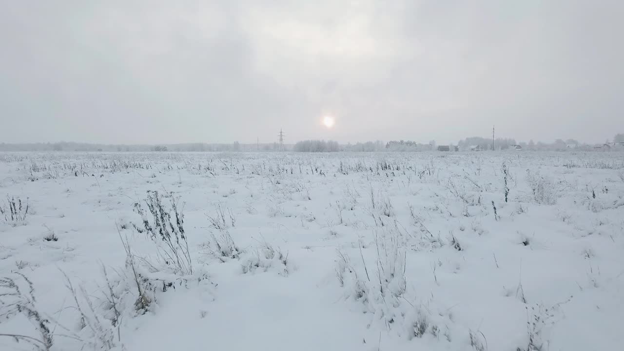 冬天，雪地上的日落。照相机低低地飞过地面视频素材