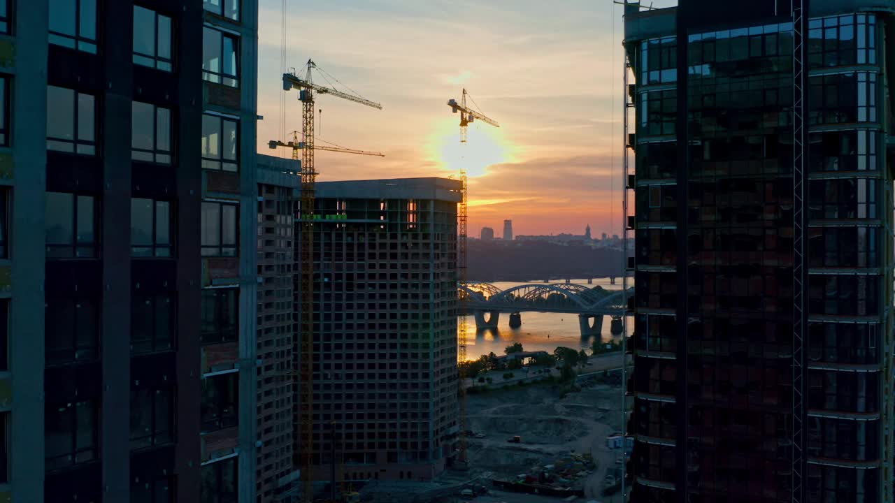 日落时分，城市建筑工地上空的空中水平飞行视频素材