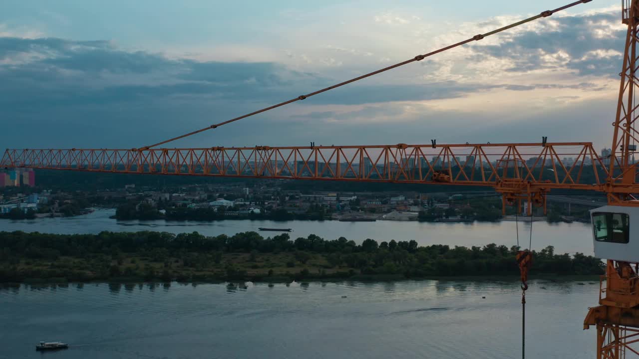 七彩夕阳下，建筑起重机空中水平飞行视频素材