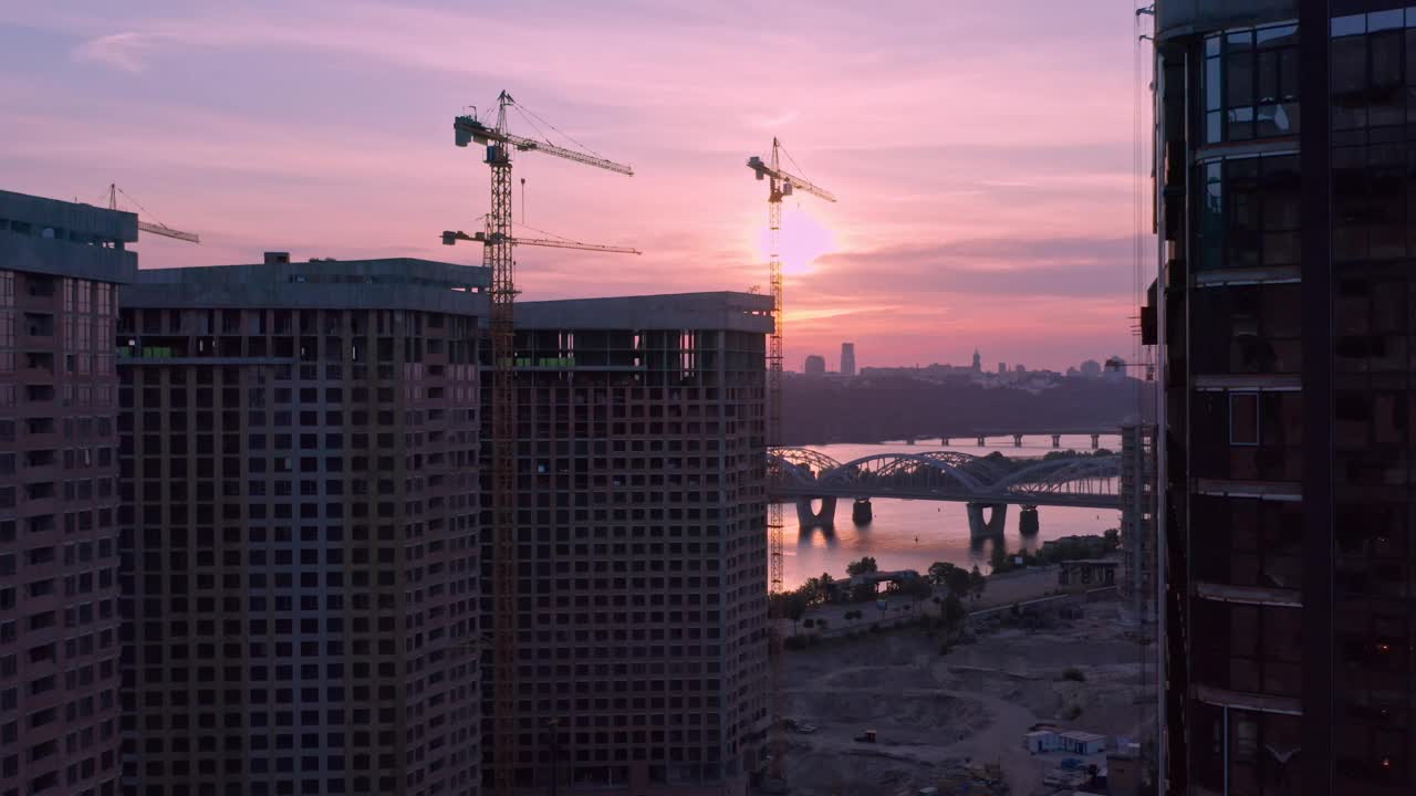 日落时分，城市建筑工地上空的空中垂直飞行视频素材