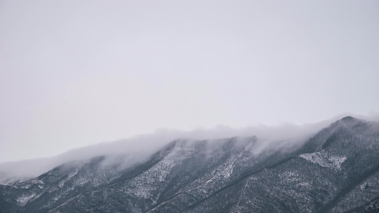 云在白雪皑皑的山脊上翻滚。延时视频素材