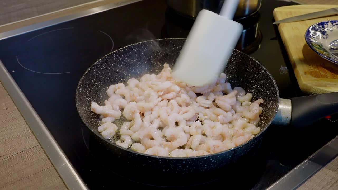 在煎锅里烤去皮虾的过程，特写。虾炒饭。家里做的海鲜视频素材