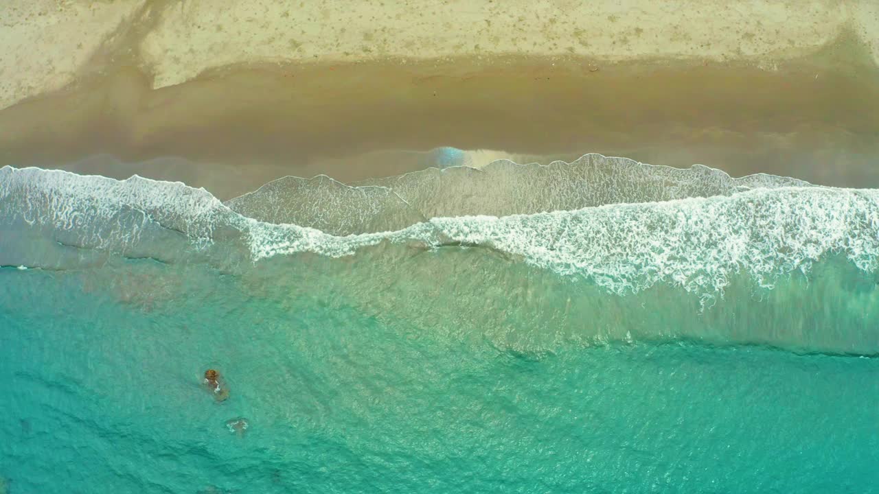 海浪冲刷海滩的沙子的鸟瞰图视频素材