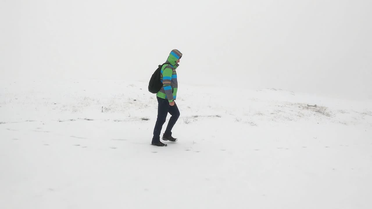 徒步旅行者背着背包在多雪多雾的山上行走在粉末雪上视频素材