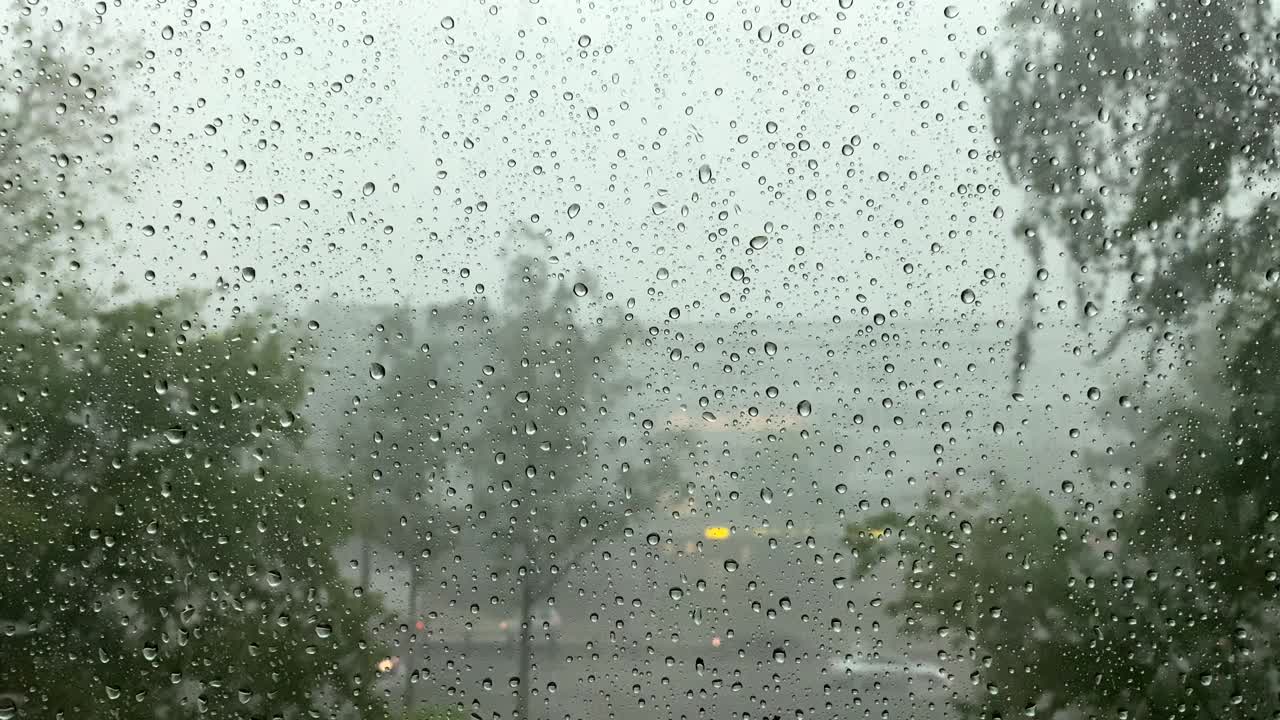 在特写镜头中，大雨中的雨滴顺着窗户流下。飓风风视频素材